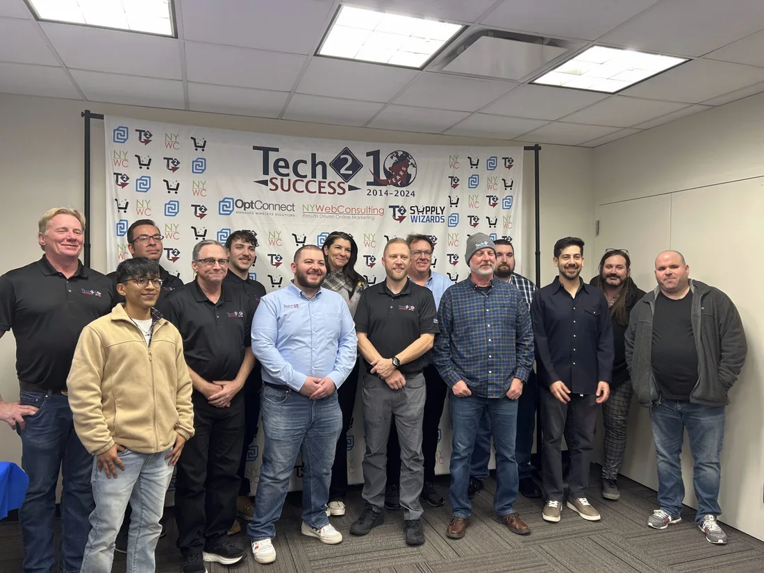 Team gathering in front of a Tech 2 Success and NY Web Consulting event backdrop